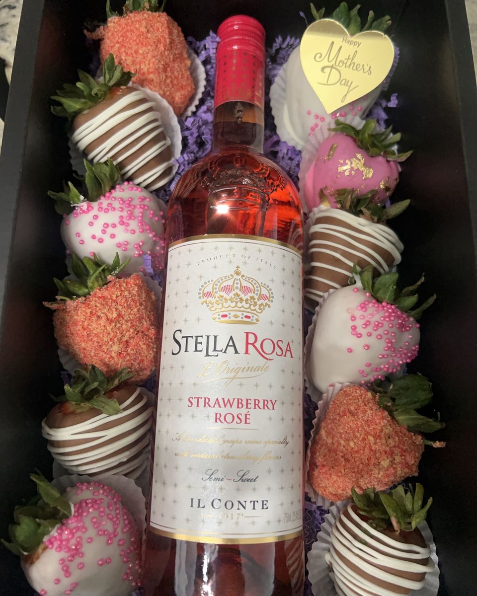 Box of striped, sprinkled and crumb-coated strawberries around a bottle of strawberry rosé
