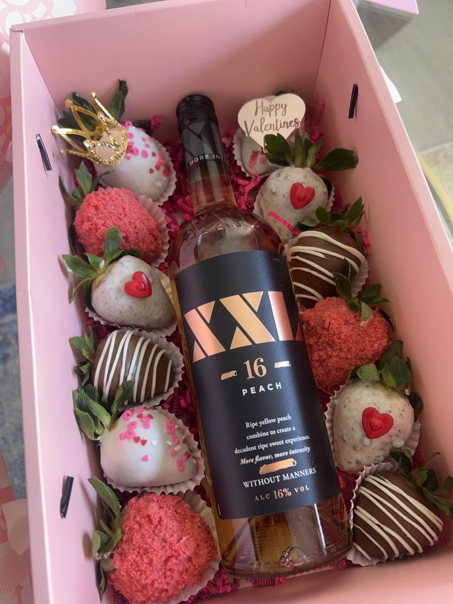 Pink gift box of gourmet strawberries around a bottle of wine with a gold crown topper